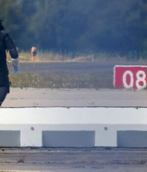 file-photo-a-police-officer-in-protective-clothing-walks-next-to-an-explosive-disarming-robot-eod-015017132-16x9_0.jpeg