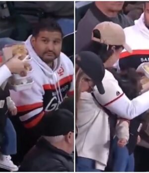woman-carries-baby--3-plates-of-food-as-man-beside-her-offers-no-help-at-game-photos-shadow-truthl-253759719-16x9_0.jpg